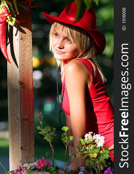 Beautiful blonde cowgirl in the countryside with red hat. Beautiful blonde cowgirl in the countryside with red hat