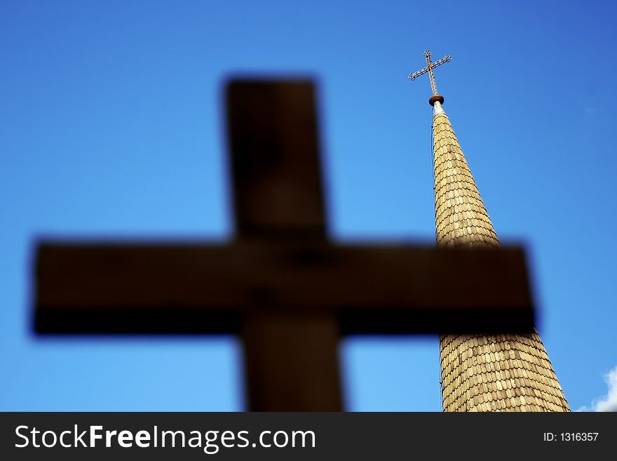 Church tower behind out of focus cross silhouette