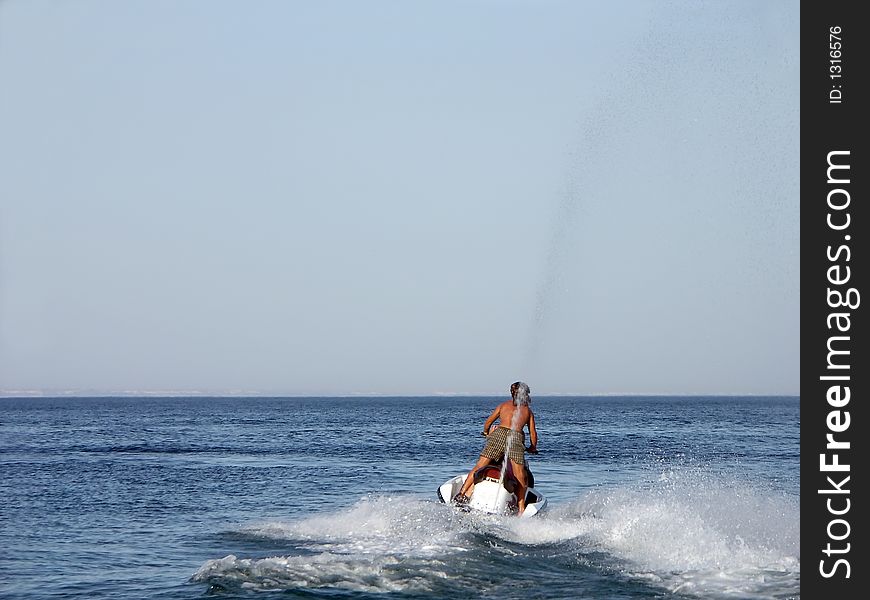 Young guy riding a jet ski. Young guy riding a jet ski