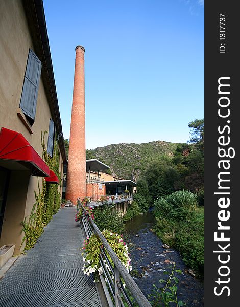 Factory with chimney along a river. Factory with chimney along a river