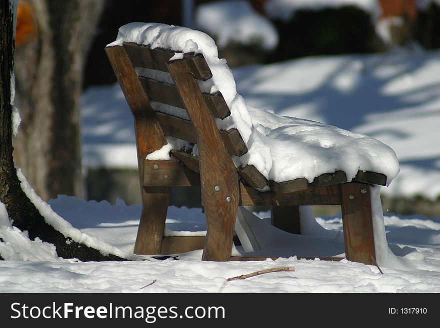 Snow covered becnh in yard. Snow covered becnh in yard