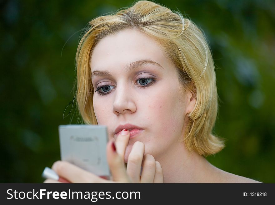 Beautiful Yong Blonde Girl With Blue Eyes Putting On Makeup