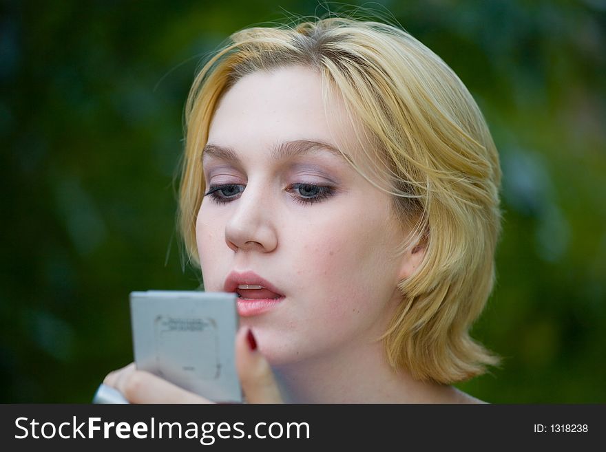Beautiful Yong Blonde Girl with Blue Eyes Putting on Makeup in the park
<A href=http://www.dreamstime.com/collection_details.php?collectionid=3611><B>More Gorgeous Caroline</B></A>