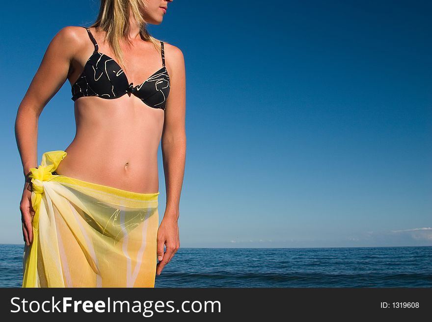 The girl with a yellow scarf on a sea background. The girl with a yellow scarf on a sea background