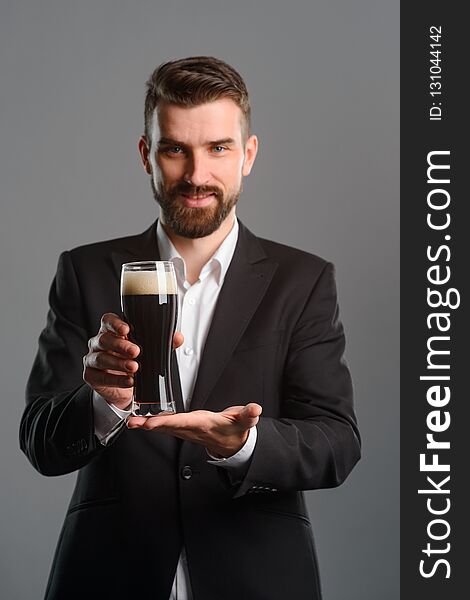 Young man showing beer glass