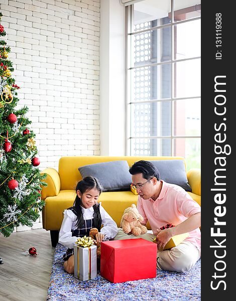 Family Decorating A Christmas Tree And Father Giving Christmas G