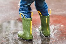 Child With Rain Boots Jumps Into A Puddle Stock Photography