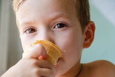 Small Boy With Charming Eyes Is Holding And Eating Ice-cream Stock Image