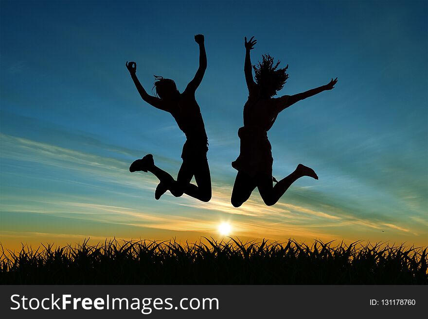 Two girls jumping for joy at sunset