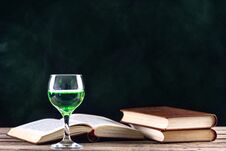 Absinthe Drink In Glass And Books With Candle In Candlestick Royalty Free Stock Photo Absinthe Drink In Glass And Books With Candle In Candlestick Royalty Free Stock Photo