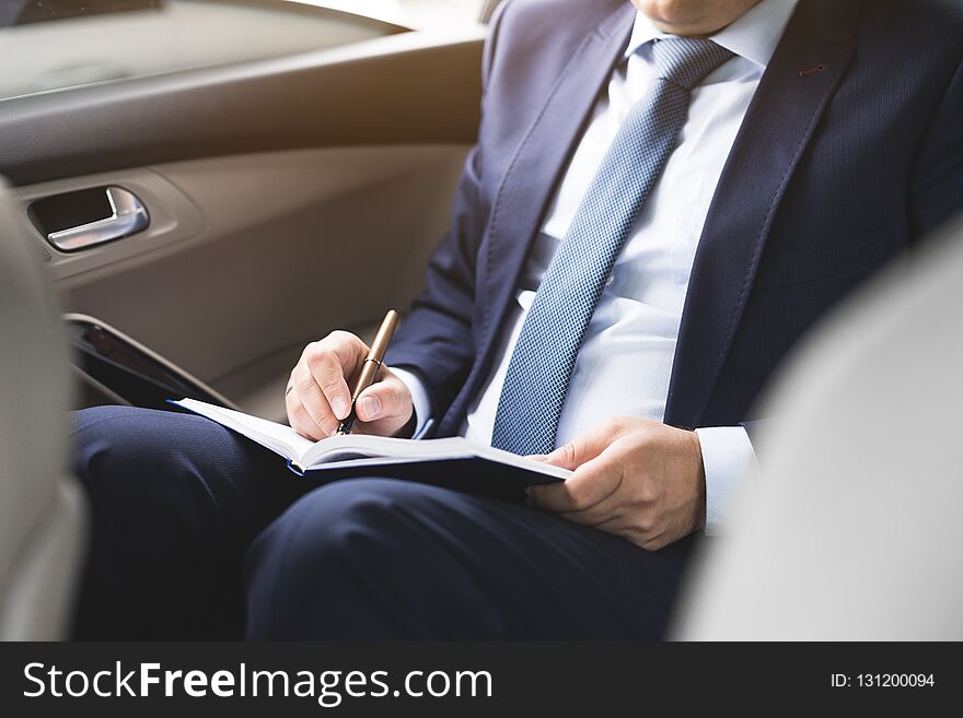 Man in a business suit write on notebook with laptop vintage tone.