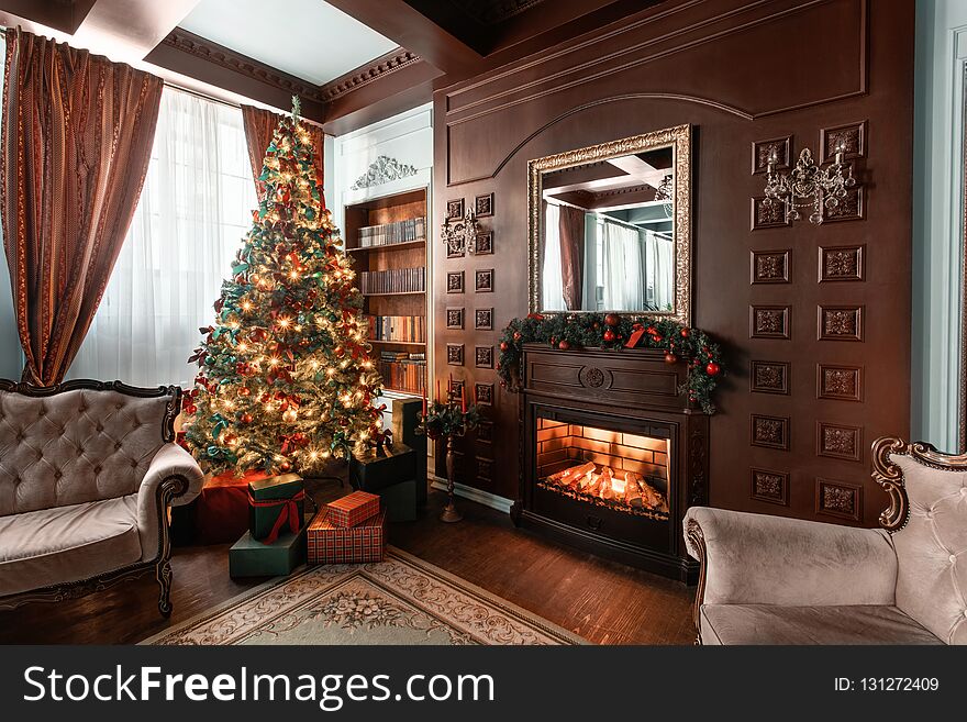 Christmas morning. Gifts at the Christmas tree. Classic apartments with a fireplace. Room with shelves of books.