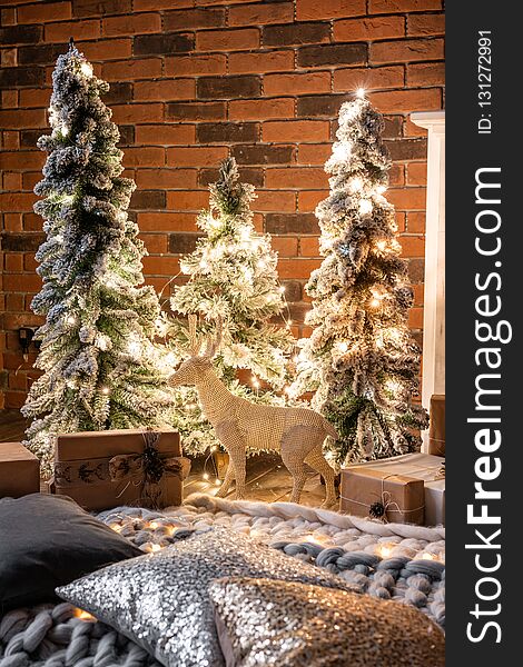 Loft apartments, brick wall with candles and Christmas tree wreath. Bed in the bedroom, high large Windows. Loft apartments, brick wall with candles and Christmas tree wreath. Bed in the bedroom, high large Windows.