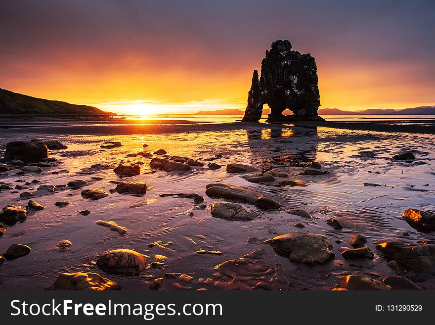 Is a spectacular rock in the sea on the Northern coast of Iceland. Legends say it is a petrified troll. On this photo Hvitserkur reflects in the sea water after the midnight sunset.