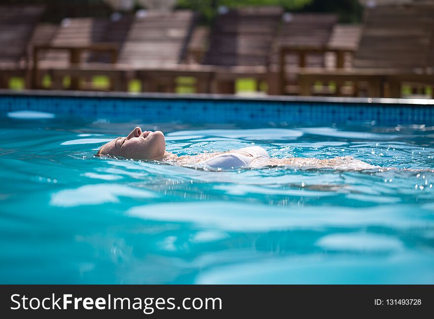 Vacation In A Tourist Resort. Woman Swims In The Pool.