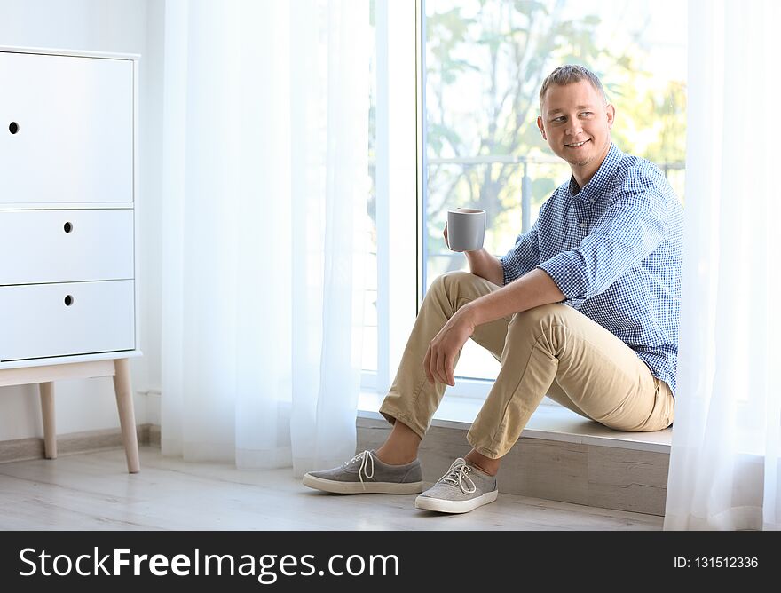 Young Man Having Rest Near Window With Open Curtains