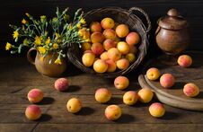 Apricots In A Basket And Flowers On The Table Stock Images