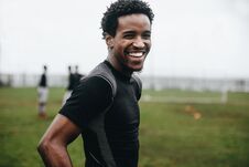 Portrait Of A Cheerful Footballer Standing On Field During Practice. Side View Of An African Soccer Player Standing On Football Stock Photography