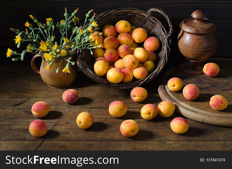 Apricots In A Basket And Flowers On The Table