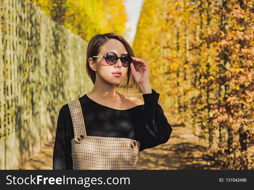 Girl in sunglasses in autumn season park