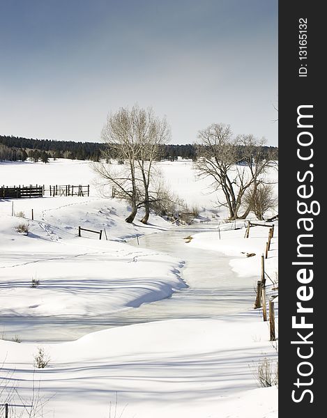 A snow covered field and frozen stream in Northern New Mexico