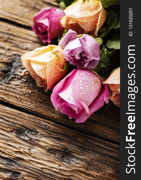 Mix of pink roses on the wooden table, selective focus