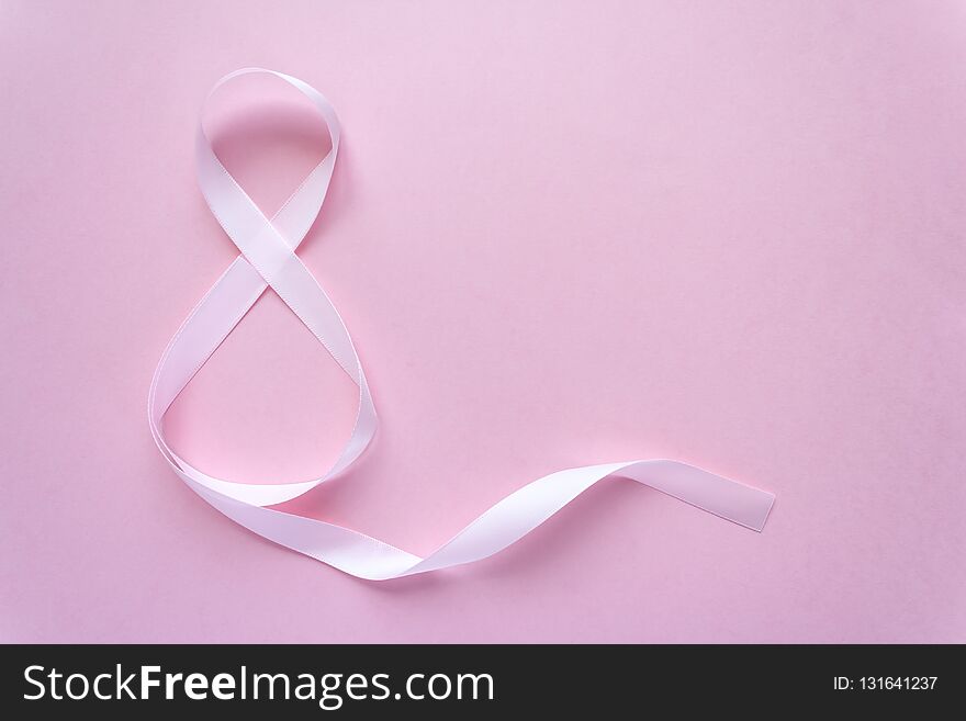 Rose gift celebration ribbon in 8 digit shape over pale pink background. Rose gift celebration ribbon in 8 digit shape over pale pink background