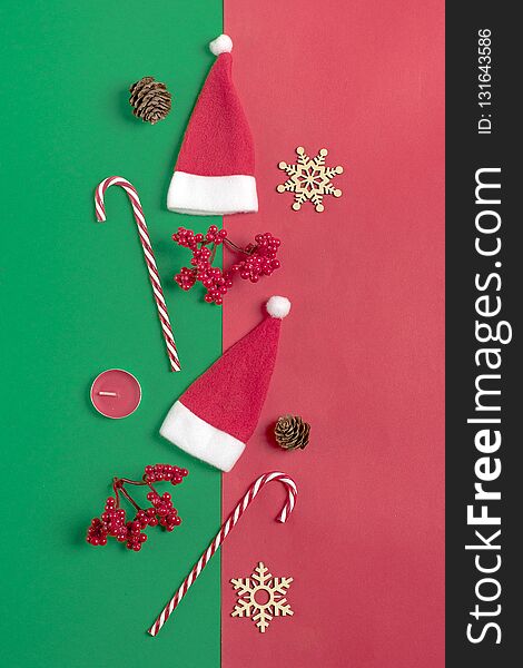 Christmas composition. Christmas decoration gifts, , Santa Claus hat , candy, snowflakes on green, red background.
