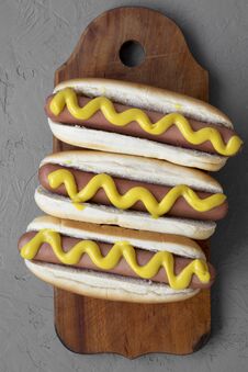 Homemade Hot Dogs With Yellow Mustard On Wooden Board Over Grey Background, Overhead View. Flat Lay, From Above Stock Image