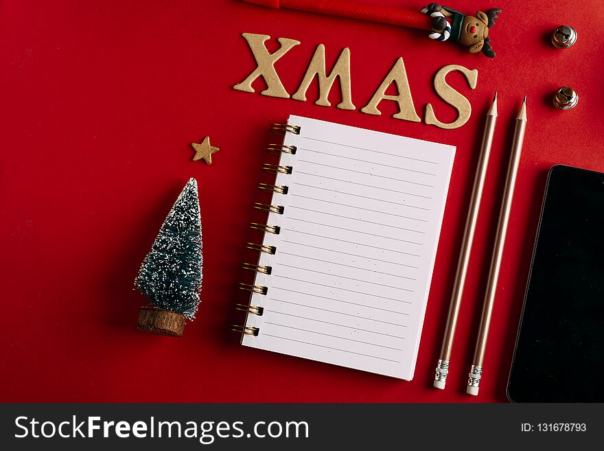 Christmas shopping list and mobile phone, Holiday planning red background, notebook and christmas decoration