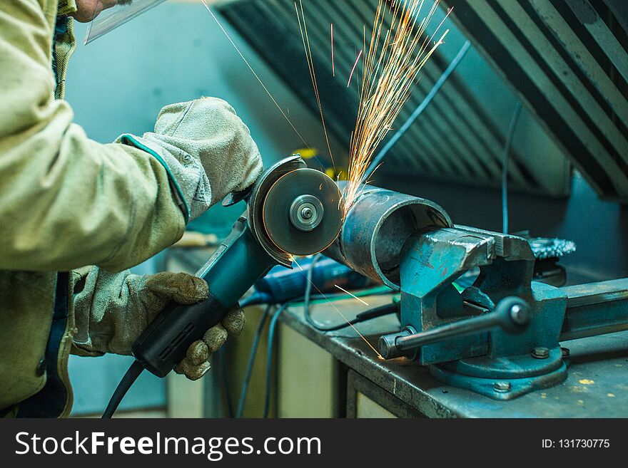 Mechanic Cleans A Welded Seam On A Section Of A Steel Pip