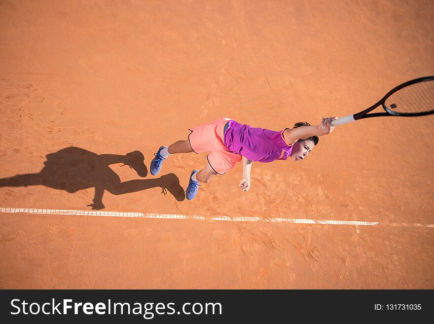 Young tennis player serving the ball with high impact