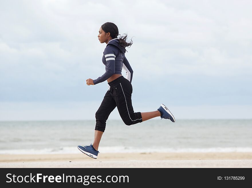 Full Body Sporty Young Black Woman Running By The Beach