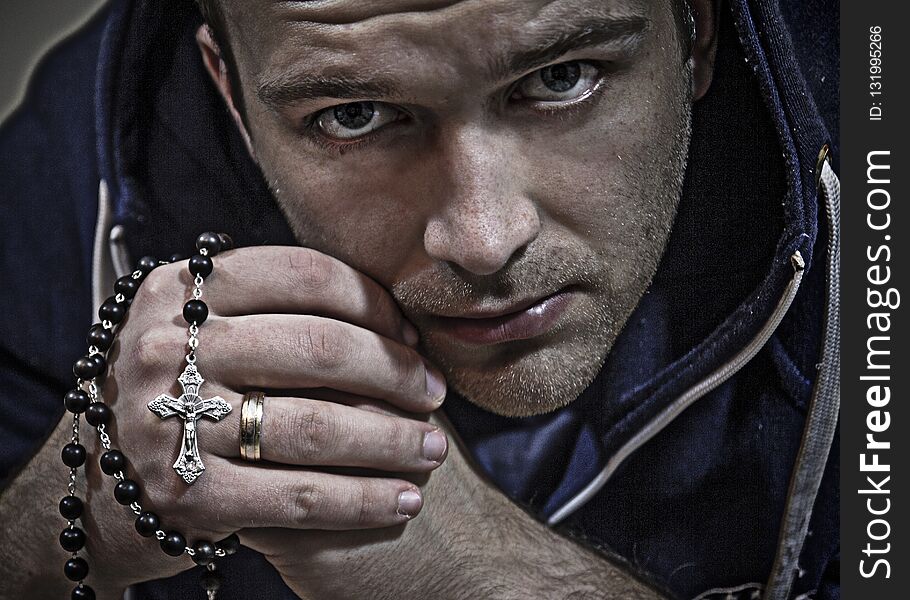 A man who prays on the rosary. He has a piercing, thoughtful look. A man who prays on the rosary. He has a piercing, thoughtful look.