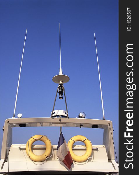 Top of a cruise ship showing buoys, radar, alarms antenna and a french flag. Top of a cruise ship showing buoys, radar, alarms antenna and a french flag.