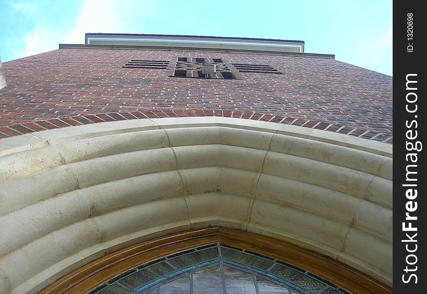 Picture of a Methodist church tower. Cross is formed in the bricks in the middle of the tower.