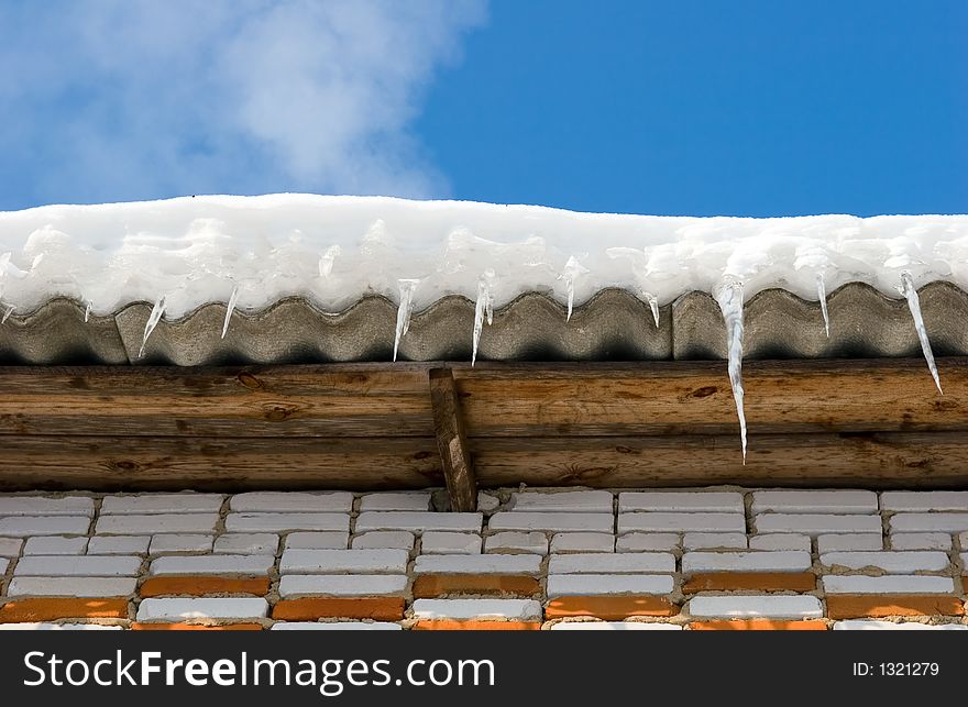 Snow covered roof with icicles