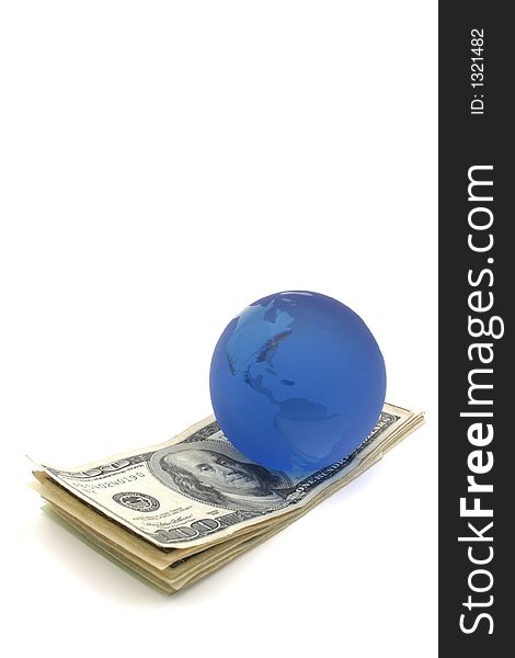 Blue glass globe paper weight on a stack of US money. Blue glass globe paper weight on a stack of US money