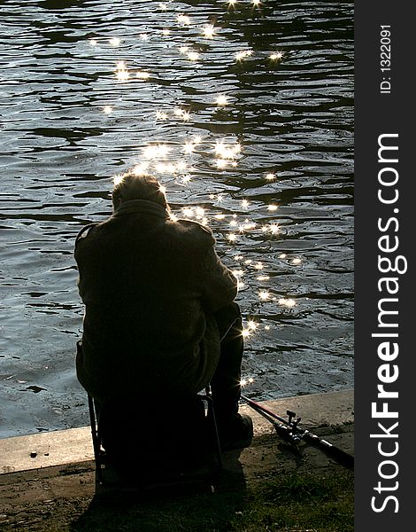Silhouette of an angler at the bank of the river IJssel in Zutphen (the Netherlands). Silhouette of an angler at the bank of the river IJssel in Zutphen (the Netherlands).