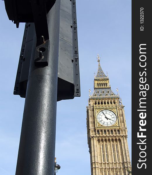 A image of the houses of Parliament sometimes nicknamed Big Ben which is located in central London. Also their is a traffic light in the image giving  a typical London City view.