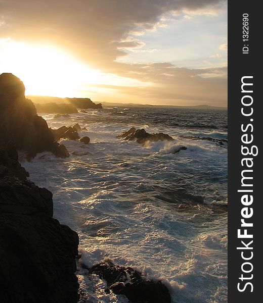 Orange sun set with rocks and waves. Orange sun set with rocks and waves