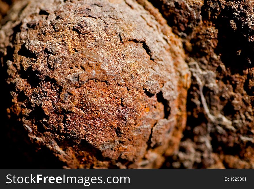 Closeup of a rusty bolt on a railroad underpass.