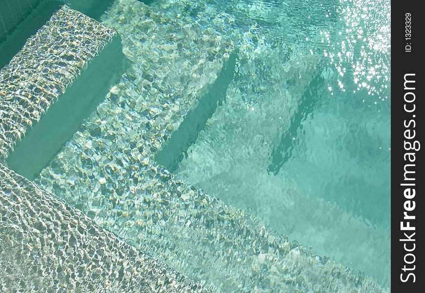 Steps leading down into a very inviting looking swimming pool. Steps leading down into a very inviting looking swimming pool.