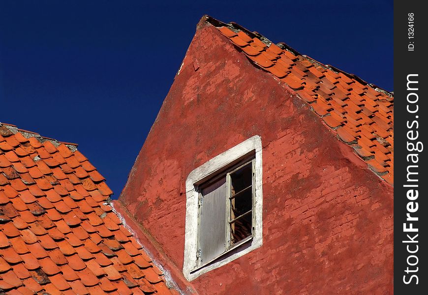 Deep blue sky over an red orange colored house front. Deep blue sky over an red orange colored house front