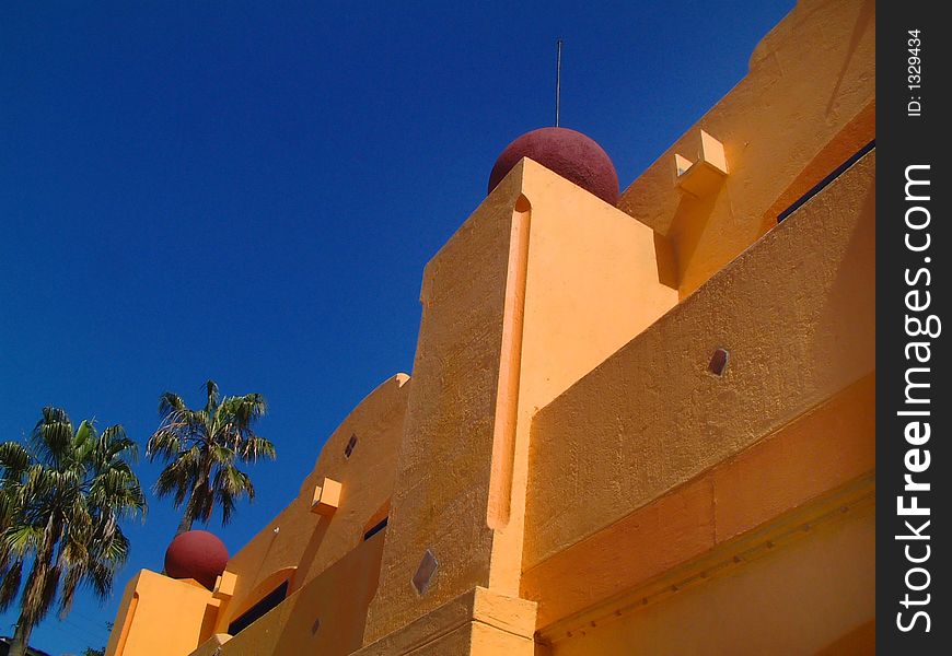 Building detail with blue sky and palm trees