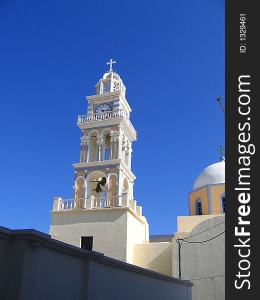 Monastery clock in santorini,greece.with the blue sky on the back. Monastery clock in santorini,greece.with the blue sky on the back