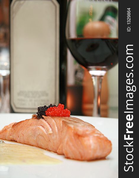 Smoked salmon slice with black and red caviar accompanied by a light butter and pepper sauce