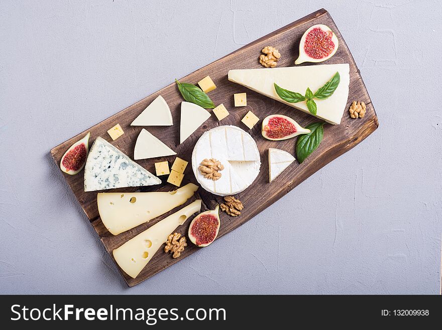 Cheeseboard with cheese brie , parmesan , camembert and dorblu . Food on wooden board