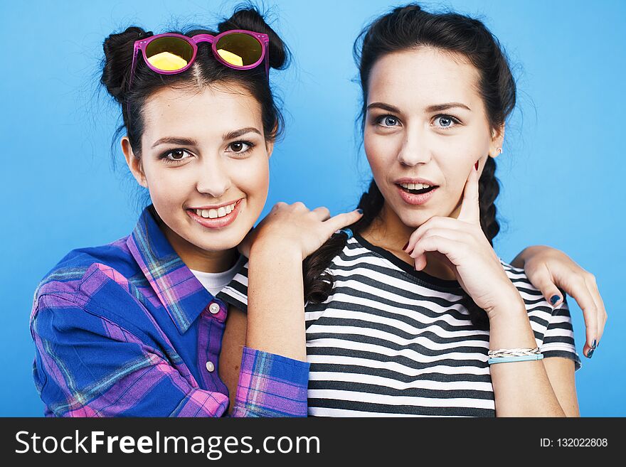 Best friends teenage school girls together having fun, posing emotional on blue background, besties happy smiling, lifestyle people concept close up