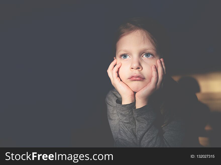 Little Sad Girl Sitting And Propping Her Head With Her Hands